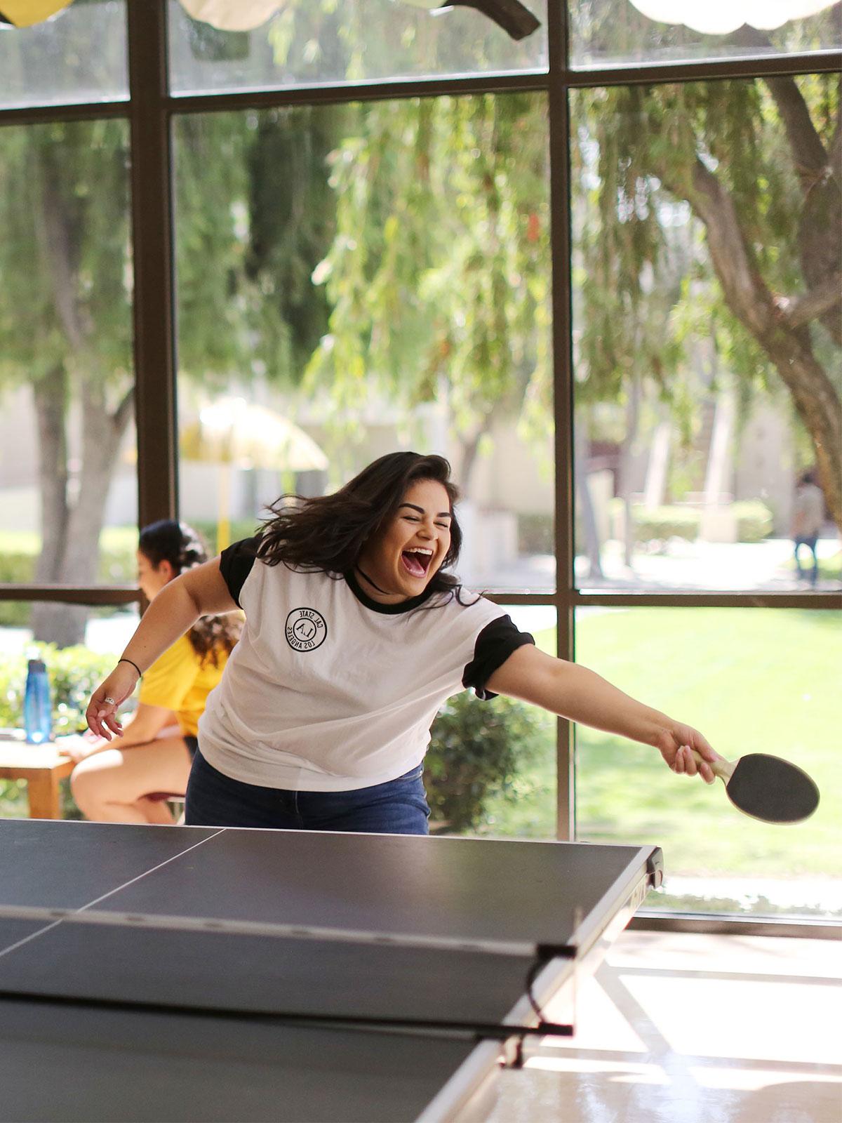 A student playing ping pong.